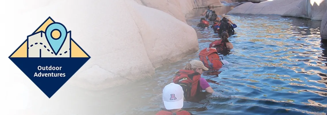 Outdoor adventure students wading through chest high water